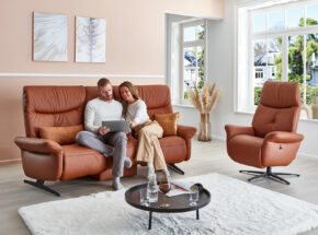 Mann Und Frau Sitzen Auf Trapezsofa Bezug Leder Longlife Nuss Mit Geschlossenem Schmetterlingstisch Und Easy Swing Sessel 02180197